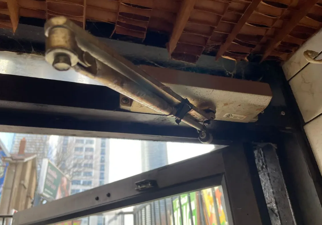 Old commercial door closer leaking oil that needs replacement