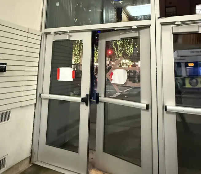 Triton Locksmith repairing aluminum storefront door closer and hardware at retail store